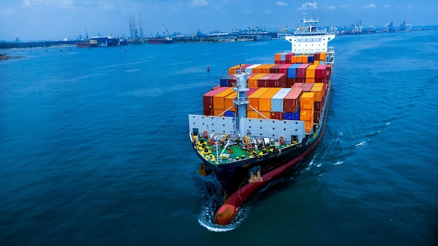 Aerial side view of cargo ship carrying container and running for export goods from cargo yard port to custom ocean concept technology transportation customs clearance