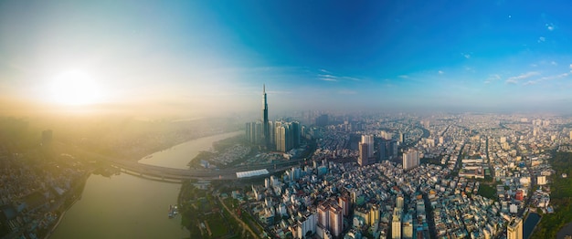 Aerial sunrise view at Landmark 81 it is a super tall skyscraper and Saigon bridge with development buildings along Saigon river cityscape in the beautiful morning with small fog around city