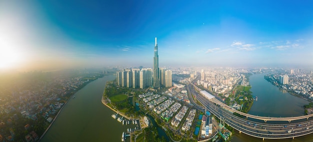 Aerial sunrise view at Landmark 81 it is a super tall skyscraper and Saigon bridge with development buildings along Saigon river cityscape in the beautiful morning with small fog around city