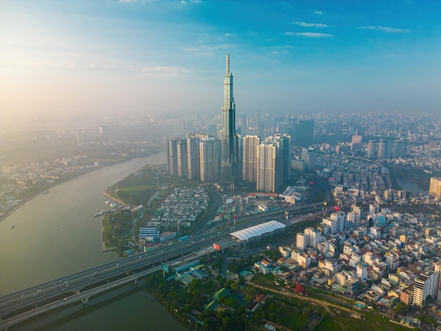 Aerial sunrise view at Landmark 81 it is a super tall skyscraper and Saigon bridge with development buildings along Saigon river cityscape in the beautiful morning with small fog around city