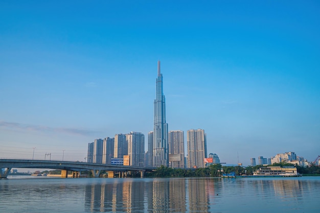 Aerial sunrise view at Landmark 81 it is a super tall skyscraper and Saigon bridge with development buildings along Saigon river cityscape in the beautiful morning with small fog around city