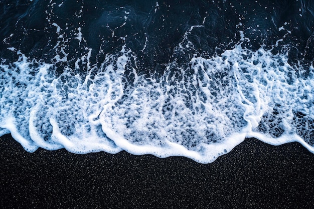 Photo aerial top down view of beautiful white blue water waves splashing over dark beach