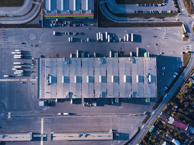 Aerial top down view of dock warehouse and trucks with semi-trailers.