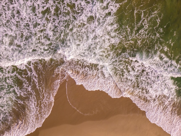 Aerial top down view on a sandy beach with sea surf nobody