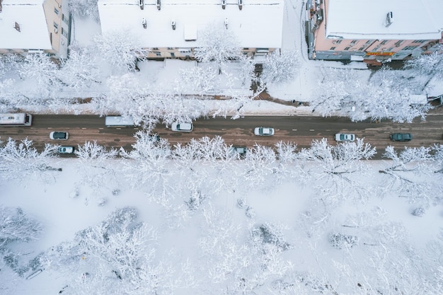 Aerial top down view of snowy city asphalt road landscapes in winter