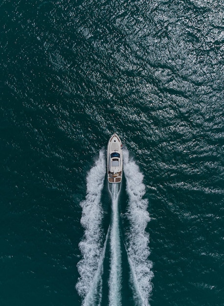 Aerial top down view of speed motor boat on open sea at summer day