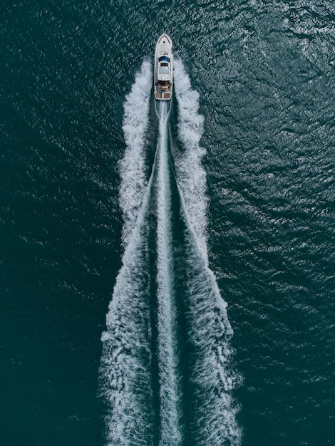 Aerial top down view of speed motor boat on open sea at summer day