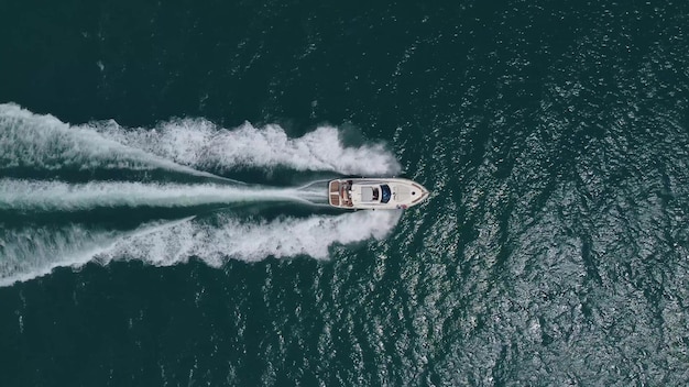 Aerial top down view of speed motor boat on open sea at summer day