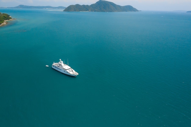 Aerial top down view of white yacht in tropical sea