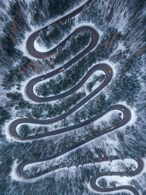 Aerial top down view of winter winding road in the forest Transylvania Romania