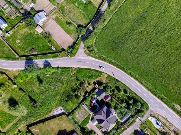 Aerial top drone view of the road, houses and fields