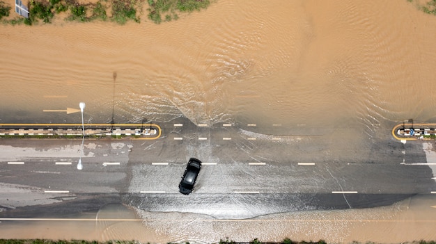 Aerial top view of Flooded the village and Country road with car, View from above shot by drone