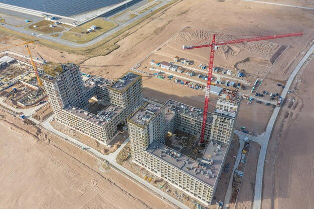 Aerial top view of highrise residential buildings under construction and cranes