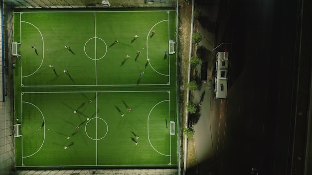 Aerial top view of a mini football match soccer MiniFootball field and Footballers from drone