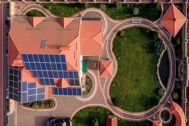 Aerial top view of new modern residential house cottage with blue panels Renewable ecological green energy production concept