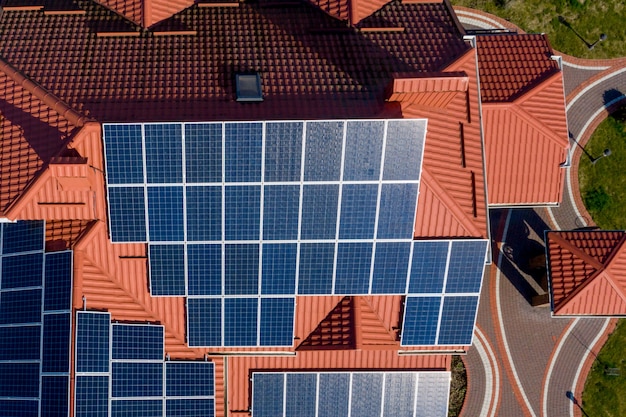 Aerial top view of new modern residential house cottage with blue panels. Renewable ecological green energy production concept