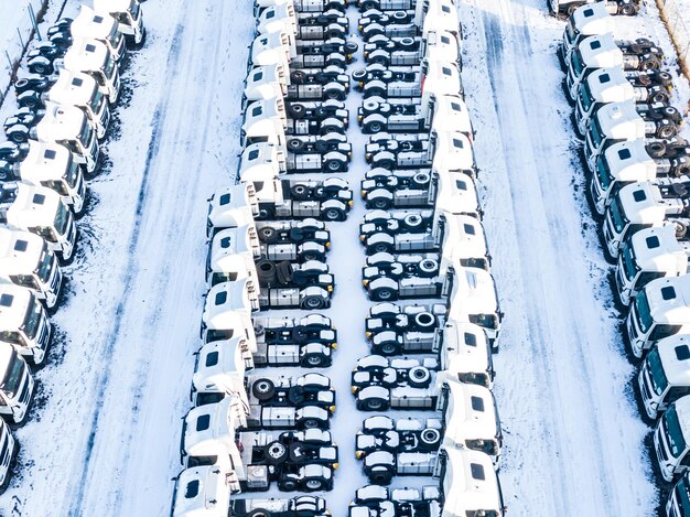 Photo aerial top view of new truck cars parking for sale stock lot row dealer inventory import