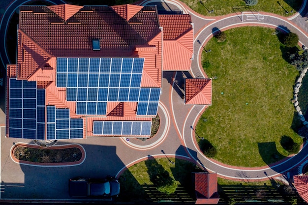 Aerial top view of a private house with paved yard with green grass lawn with concrete foundation floor.