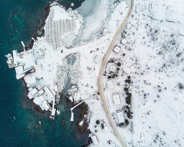 Aerial top view of road with pier in coastline and arctic ocean on winter