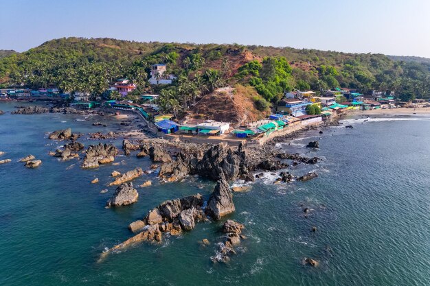 Aerial top view on tropical beach with green palm trees under sunlight Drone view in Goa