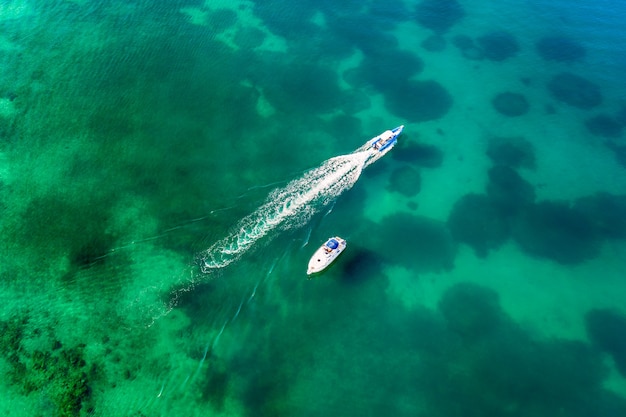 Aerial view of amazing boats in Croatia. Minimalistic landscape background with boats and sea in marina bay. Top abstract view from drone of harbor with yacht and sailboat.