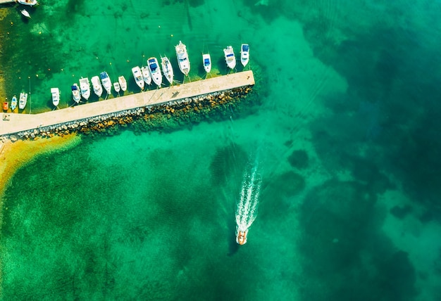 Aerial view of amazing boats in Croatia. Minimalistic landscape background with boats and sea in marina bay. Top view from drone of harbor with yacht, motorboat and sailboat. Beautiful port