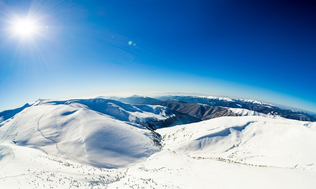 Aerial view of an amazing mesmerizing view of a mountain winter landscape on a sunny frosty day at a ski resort