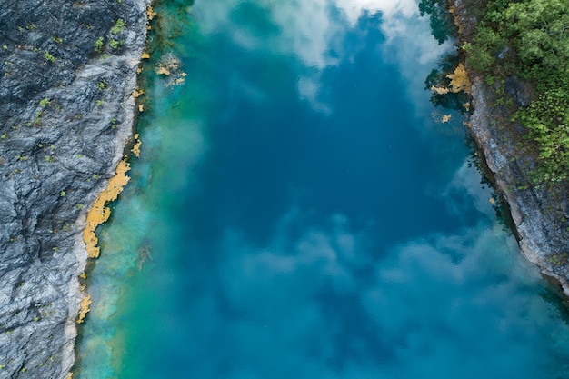 Aerial view of amazing pond in tropical rainforest forest with mountain rocks peak Beautiful water surface in Phang Nga Thailand