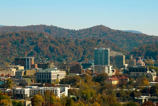 Aerial view of Asheville city in North Carolina with high buildings and mountain hills in distance