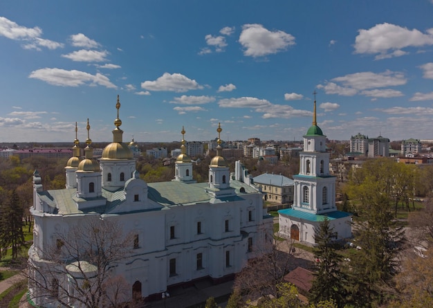 Aerial view to The Assumption Cathedral and his bell tower in Poltava orthodox church at summer lanscape with green trees