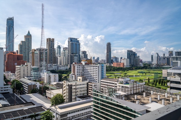 Aerial view of Bangkok cityscape in the morning showing highrises with a golf course and cloudy sky