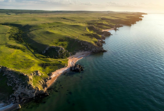 Aerial view of beach Big hills around Sunny day at dawn Greenish sea Drone Photo