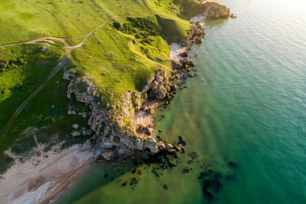 Aerial view of beach Big hills around Sunny day at dawn Greenish sea Drone Photo