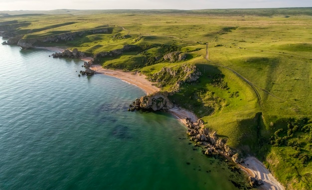 Aerial view of beach Big hills around Sunny day at dawn Greenish sea Drone Photo