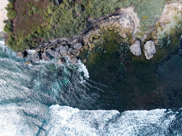 Aerial view of beautiful blue sea waves breaking on sandy coastline