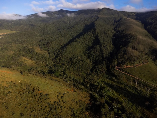 Aerial view of beautiful forest full of nature and pasture fields in Tremembe in Vale da Paraiba in Sao Paulo Mountains and hills in sunny day Lots of green and tropical vegetation Drone Sunset