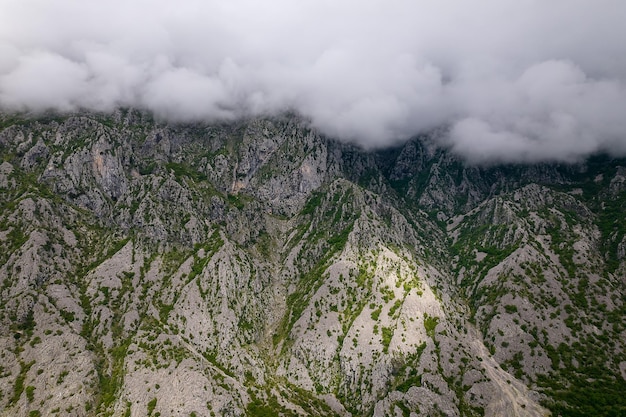 Aerial view of beautiful rocky mountains covered with clouds in Kotor bay Montenegro