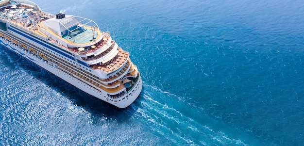 Aerial view of beautiful white cruise ship above luxury cruise close up at stern of cruise sail with contrail in the ocean sea concept tourism travel on holiday take a vacation time on summer