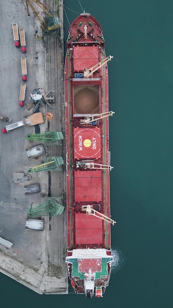 Aerial view of big cargo ship bulk carrier is loaded with grain of wheat in port