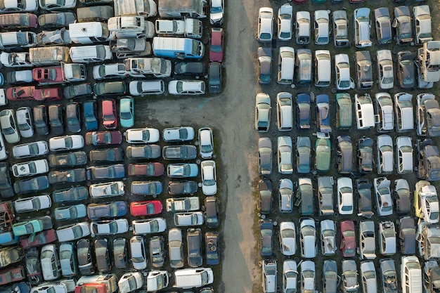 Aerial view of big parking lot of junkyard with rows of discarded broken cars Recycling of old vehicles