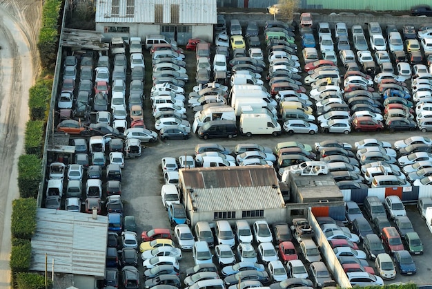 Aerial view of big parking lot of junkyard with rows of discarded broken cars Recycling of old vehicles