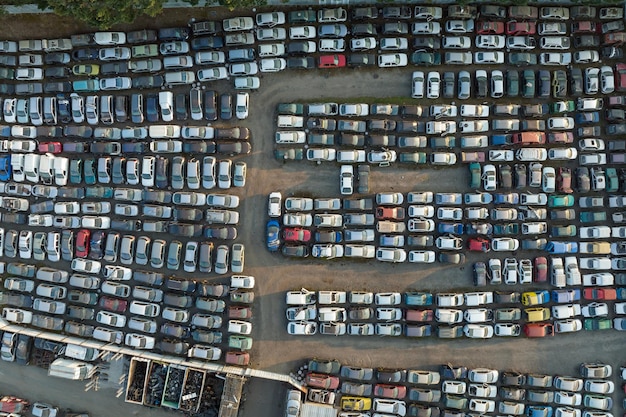 Aerial view of big parking lot of junkyard with rows of discarded broken cars Recycling of old vehicles