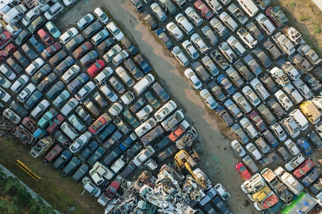 Aerial view of big parking lot of junkyard with rows of discarded broken cars Recycling of old vehicles