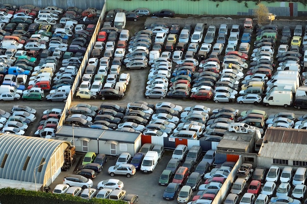 Aerial view of big parking lot of junkyard with rows of discarded broken cars Recycling of old vehicles