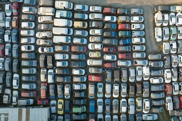 Aerial view of big parking lot of junkyard with rows of discarded broken cars Recycling of old vehicles