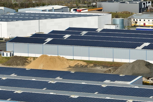 Aerial view of blue photovoltaic solar panels mounted on industrial building roof for producing green ecological electricity Production of sustainable energy concept