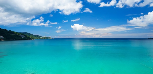 Aerial view of a blue sea surface water texture background Amazing sky white clouds Aerial flying drone view Waves water surface texture on sunny tropical ocean in Phuket island Thailand