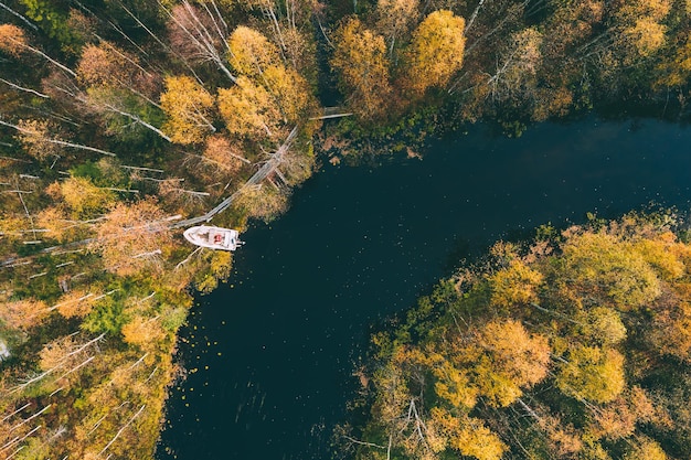 Aerial view of blue winding river and fall forest with autumn colorful trees