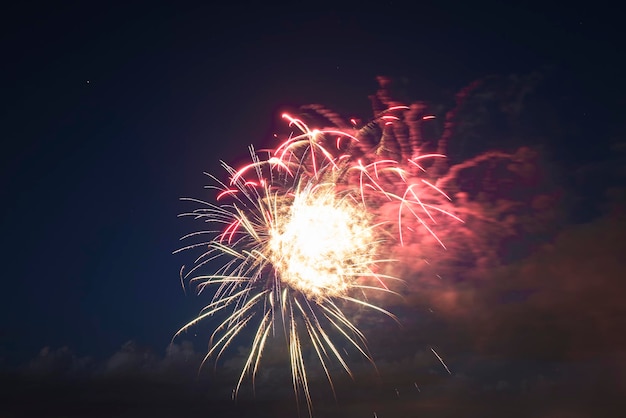 Aerial view of bright fireworks exploding with colorful lights against dark night sky on US Independence day holiday