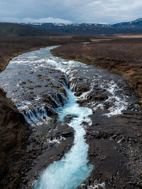 Aerial view of Bruarfoss Waterfall Icelands bluest waterfall with vibrant blue water flowing over stones Most famous place in Iceland